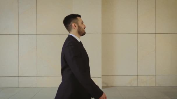 Gelukkige zakenman wandelen rond de stad, succesvolle en zelfverzekerde man op de achtergrond van een modern gebouw. — Stockvideo