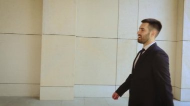 Mutlu işadamı şehir etrafında yürüyüş, modern bir binanın arka planda başarılı ve kendine güvenen adam.