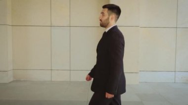 Mutlu işadamı yürüyüş ve şehir etrafında konuşurken, modern bir binanın arka planda başarılı ve kendine güvenen adam.