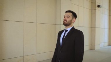 Mutlu işadamı şehir etrafında yürüyüş, modern bir binanın arka planda başarılı ve kendine güvenen adam.