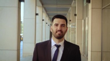 Mutlu işadamı şehir etrafında yürüyüş, modern bir binanın arka planda başarılı ve kendine güvenen adam.