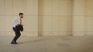 Evrak çantası olan işadamı şehir caddesinde koşuyor. İş adamı toplantıya geç geldi. Modern binanın yakınında koşu kıyafeti giymiş başarılı bir adam. Adam randevu için acele.