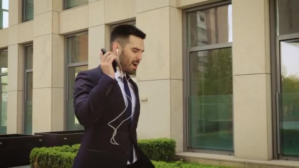 Felice uomo d'affari di successo Ballando in auricolari wireless — Video Stock