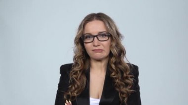 Kamerada hayal kırıklığına uğramış kadın dudaklarını ısırır sonra gri arka plana, yavaş çekime doğru silker.