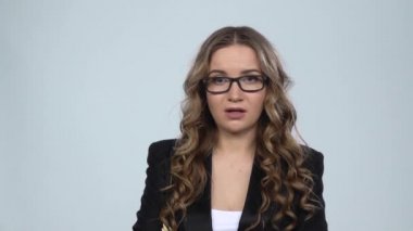 Kadın hayal kırıklığına kamera görünüyor ve omuz silkme sonra gri arka plan, yavaş hareket karşı başını hayır sallayarak