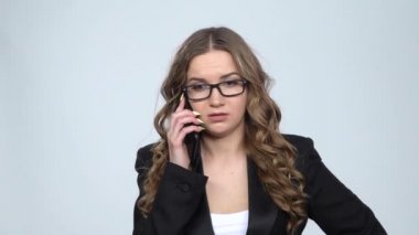 Gri arka planda akıllı telefonda bağıran kızgın iş kadınının portresi, yavaş çekim.