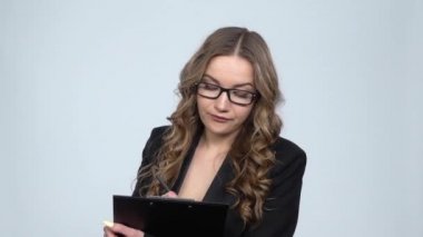 Pano tutan kadın ofis çalışanı etrafına bakar ve notlar yapar, yavaş çekim