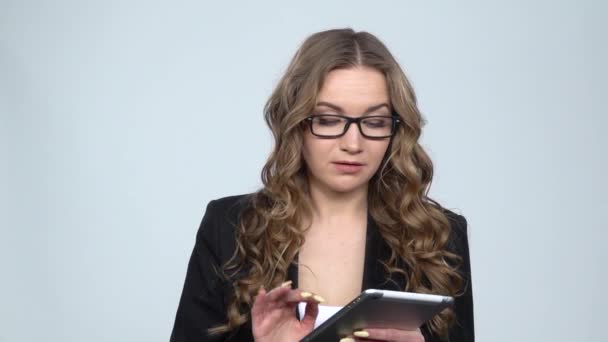 Pensive senhora mensagens de texto em seu tablet em fundo cinza no estúdio, câmera lenta — Vídeo de Stock