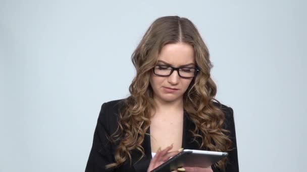 Lady texting on her tablet on gray background in studio, slow motion — Stock Video