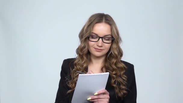 Женщина в деловом костюме пишет в блокноте, замедленной съемки — стоковое видео