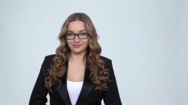 Gri arka planda kameraya bakan gülümseme ve heyecan ile iş kadını, yavaş hareket