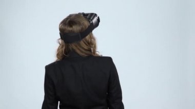 Vr konsepti. Gri arka planda sanal gerçeklik gözlüğü olan kadın, yavaş çekim