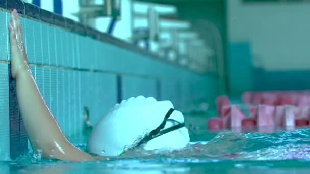 Swim finish. Portrait of professional Teenager girl swimmer in goggles emerging from swimming pool. Woman finishing swimming race. — Stock Video