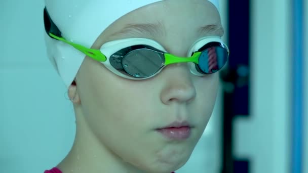 Dziewczyna Nastolatka w goglach patrząc na kamerę w basenie, zbliżenie. — Wideo stockowe