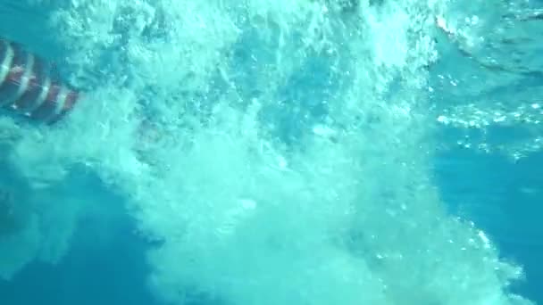Podvodní pohled na dívku skákající do bazénu, pomalý pohyb — Stock video