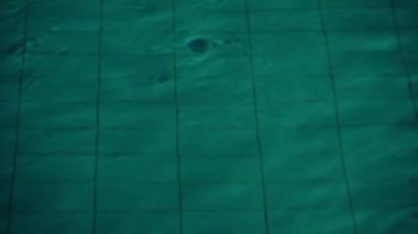 Gece yüzme havuzunda derin su üzerinde dalgalar yakın.