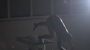 Erkek yüzücü başlangıç blok kapalı atlar ve havuzda yüzmeye başlar. Profesyonel atlet eğitimi: dalış ve su yüzeyi sıçramaları. Gece çekimi