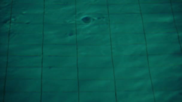 Close-up van golven over diep water in nacht zwembad. — Stockvideo