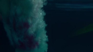 Havuza atlayan kızın sualtı görünümü, yavaş çekim. Sualtı manzarası. Gece çekimi.