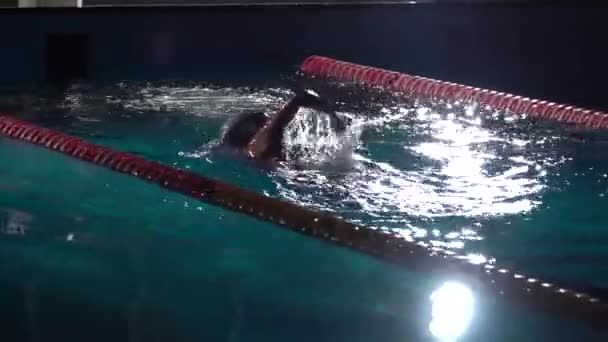 Yüzme finali. Yüzücü güneşli bir günde mavi su ile su havuzunda eylem. Gece çekimi — Stok video
