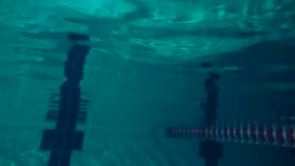 Vista subaquática de menina pulando na piscina, câmera lenta. Vista subaquática. Tiro noturno . — Vídeo de Stock