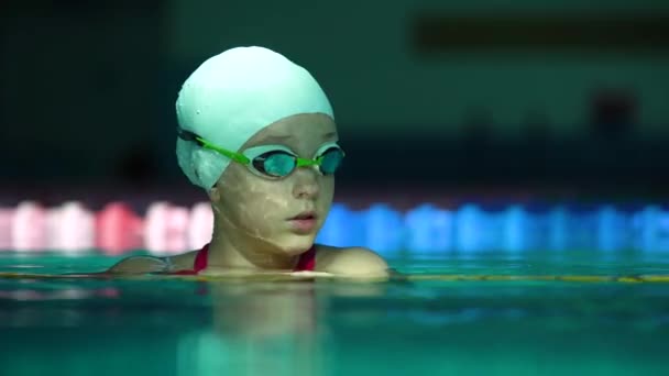 Retrato de una adolescente nadadora profesional con gafas que emergen de la piscina — Vídeo de stock