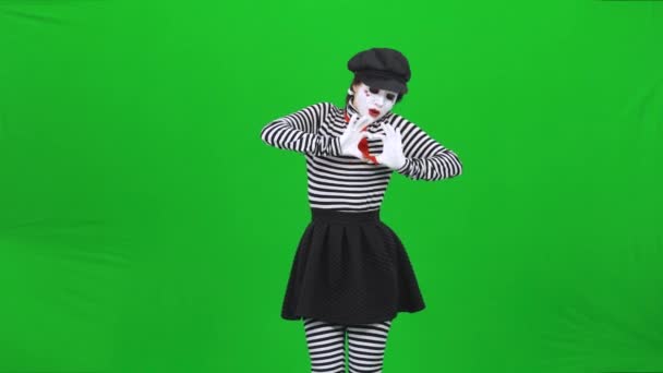 MIME dívka ukazuje, jak tluče srdce, posílá polibky. Klíč Chroma. — Stock video