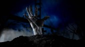 strašidelný hřbitov s zombie ruka přichází ze země