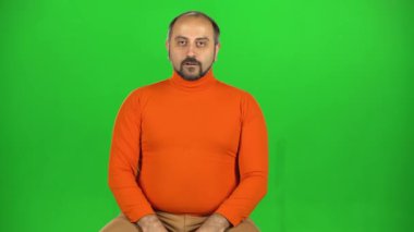 Beyaz bir adam kameraya bakıp flört ediyor ve başını sağa sola sallıyor. Yeşil Ekran