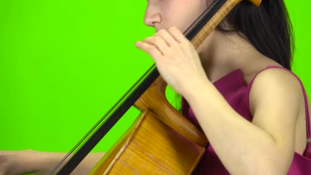 La ragazza blocca il violoncello con le dita. Schermo verde. Vista laterale. Da vicino. — Video Stock