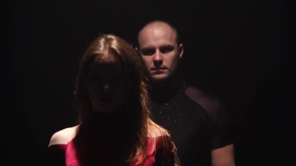 Couple dansant sur le fond noir sous les projecteurs dans un studio sombre, puis la lumière s'éteint. Mouvement lent — Video