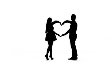 Sevgi dolu bir çift, ellerin yardımıyla kalp şekli oluşturur. Siluet. Beyaz arka plan. Yavaş çekim