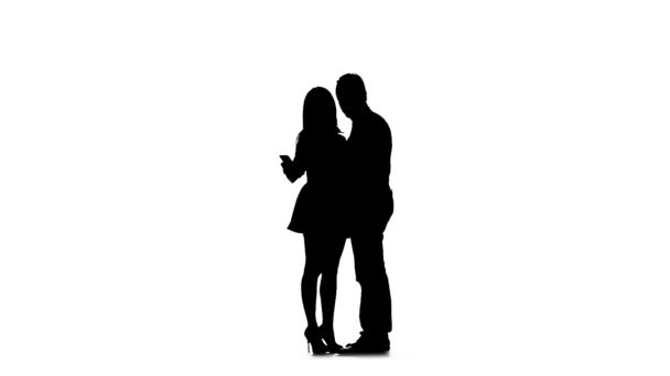 Un couple aimant fait du selfie. Silhouette. Fond blanc. Mouvement lent — Video