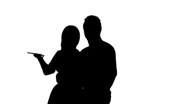 Un couple aimant fait du selfie. Silhouette. Fond blanc. Au ralenti. Gros plan — Video