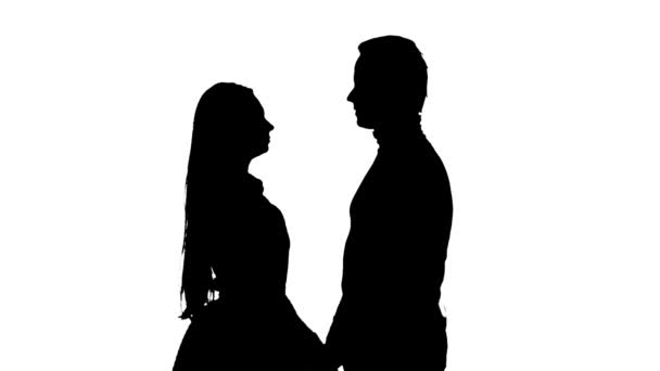 Meisje met een man kijkt naar de poster en kiest voor een film. Silhouet. Witte achtergrond. Slow motion — Stockvideo