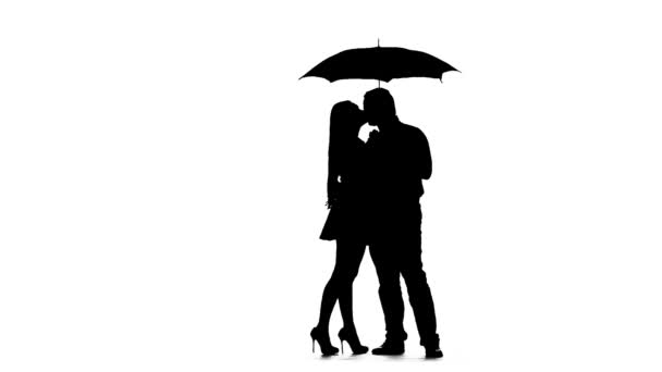 Pair kissing under the umbrella. Silhouette. White background. Slow motion — Stock Video