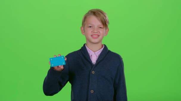 Dítě chlapec s kreditní kartou ukazuje jako na zelené obrazovce — Stock video