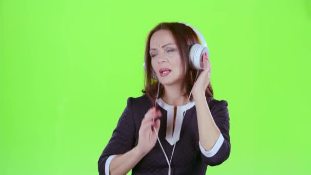 Mujer escuchando música con auriculares. Pantalla verde — Vídeos de Stock