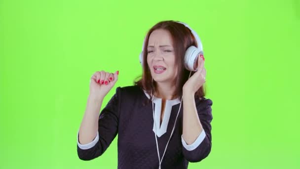 Señora escuchando música en los auriculares. Pantalla verde — Vídeos de Stock