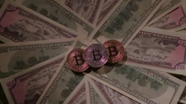 Farklı madeni paraların Bitcoin 'i kağıt banknotlar üzerinde bir masanın üzerinde yatıyor.