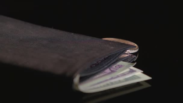 Bitcoin and paper currency are in a black wallet. Black background. Close-up — Stock Video