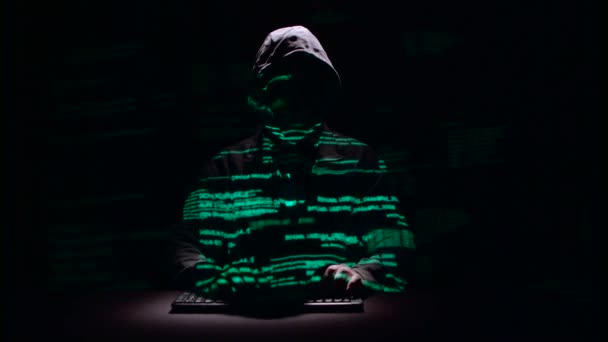 Guy schrijft patches voor het hacken van websites. Zwarte achtergrond. Silhouet — Stockvideo