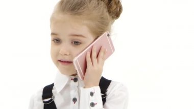 Kız çocuğu beyaz arka planda cep telefonuyla iletişim kurar. Yakın çekim.