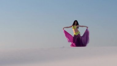 Parlak takım elbiseli profesyonel dansçı cinsel hareketler mavi gökyüzüne karşı yapar.