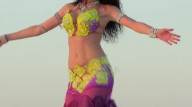 Çölde elinde peçesi olan bir kız vücudunu seksüel olarak hareket ettiriyor. Kapat.