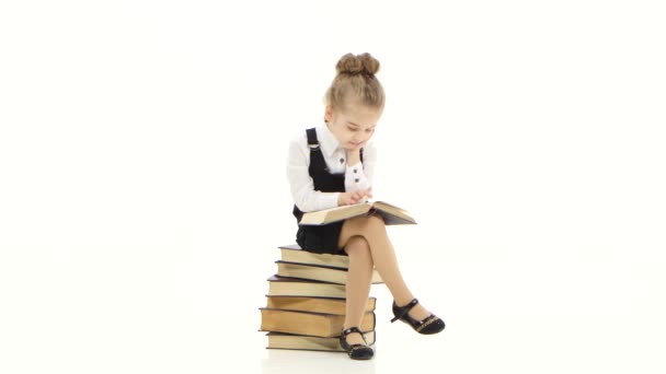 Pozorné dítě školačka čte zajímavou knihu o bílém studiu — Stock video