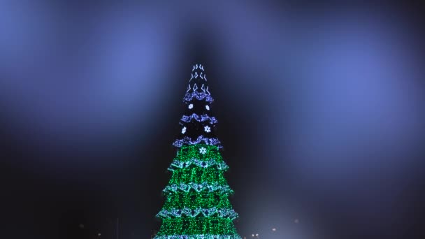 Árvores de Natal com luzes bokeh embaçadas brilhantes nas ruas da cidade. Imagens desfocadas de Natal — Vídeo de Stock