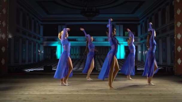 Grupo jovens bailarinas hábeis dançando balé moderno no palco de grande salão. Meninas a olhar para o auditório. Ensaio vestido antes do desempenho . — Vídeo de Stock