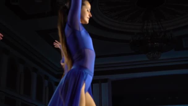 群青技艺娴熟的芭蕾舞演员在大礼堂的舞台上跳起现代芭蕾。女孩们看着礼堂。演出前的彩排. — 图库视频影像