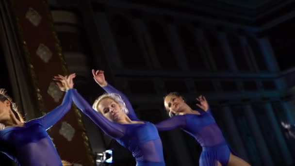 Groep jonge bekwame ballerina's dansen modern ballet op het podium van de grote zaal. Meisjes kijken naar Auditorium. Jurk repetitie voor de prestaties. — Stockvideo